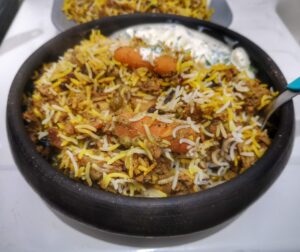 Hyderabadi Veg Dum Biryani and Raita in a serving bowl