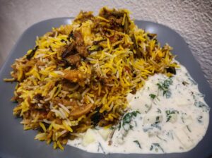 Hyderabadi Veg Dum Biryani and Raita in a plate
